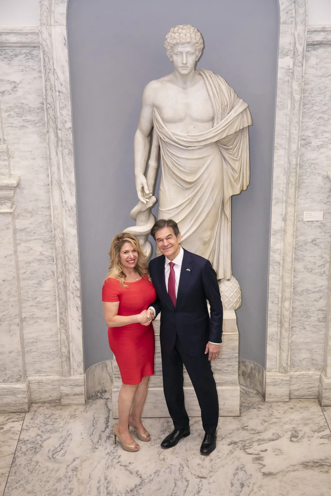 Penny Foskaris with Dr. Oz in a formal marble hall setting